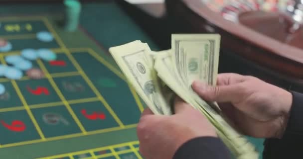 プレイヤーはドルをカウントする カジノのプレイヤーはカネを数える カジノでの勝利を数える 男はドルをクローズアップする — ストック動画