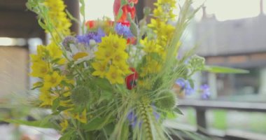 Festival masasında bir buket çiçek. Masada güzel çiçekler var. Masada bir buket çiçek var..