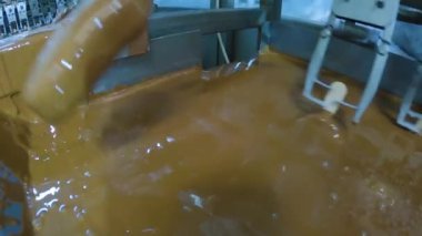 The chocolate drips nicely off the ice cream. Chocolate dripping from ice cream slow motion. Ice cream is dipped in chocolate at the factory.