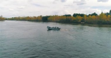 Devriye botları bir İHA 'dan görüldüğü gibi nehir boyunca ilerliyorlar. Nehirde yüksek hızlı devriye botu
