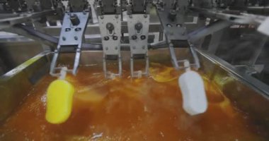Ice cream is covered with bright glaze. Ice cream in yellow glaze. Colorful yellow ice cream on the conveyor.