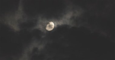 Gece gökyüzündeki parlak ay, yüzen bulutların arka planına karşı. Dolunay gökyüzünde yüzen bulutların arka planına karşı. Gece gökyüzünde ay ve bulutlar