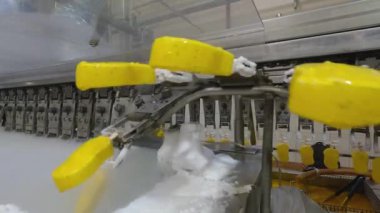 Ice cream is dipped into a container with fruit glaze. Colorful bright ice cream on the conveyor. Ice cream production.