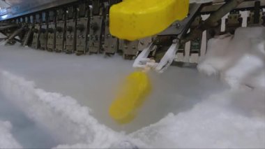 Ice cream is dipped into a container with fruit glaze. Colorful bright ice cream on the conveyor. Ice cream production.