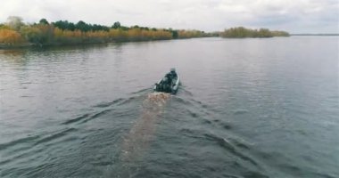 Devriye botları bir İHA 'dan görüldüğü gibi nehir boyunca ilerliyorlar. Nehirde yüksek hızlı devriye botu