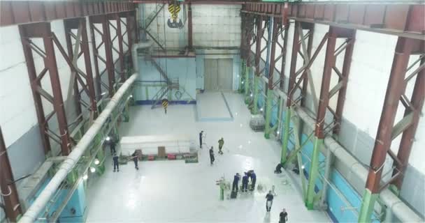 建筑商将聚合物涂层涂在工业建筑物的地板上 一组专业人员在工厂车间里做一个聚合物地板 — 图库视频影像