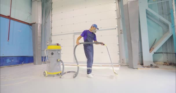 ビルダーは 建設掃除機を使用して塵の建設現場をきれいにします 塵から建設現場を掃除する 仕事を終えた後ポリマーの床を掃除するプロセス — ストック動画