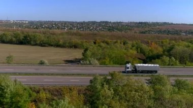 Kamyon güneşli havada otoyol boyunca sürer. Kamyon modern bir yolda gidiyor. Pistte kamyon var.