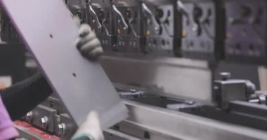 Hidrolik levha metal bükme makinesi. Bir işçi bir makinede metal bir parçayı büker.