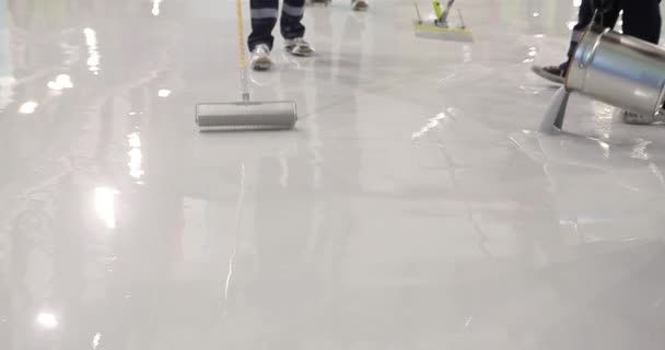 一名建筑工人在建筑工地上工作 一名建筑工人用尖角滚子涂上树脂地板 聚合物底板的制作过程 — 图库视频影像