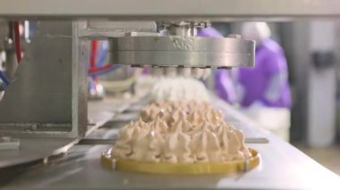 Otomatik dondurma üretimi. Dondurmalı pasta yapmak için otomatik taşıyıcı. Dondurma tüplerden güzelce çıkarılmış..
