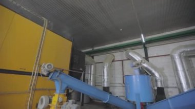 Modern bir ahşap talaş sobası. Fabrikadaki modern bir kazan dairesi. Sanayi ocağı ahşap işçiliğinin atıkları üzerinde çalışıyor. Soba ahşap işçiliğinden gelen atıklarla çalışıyor.