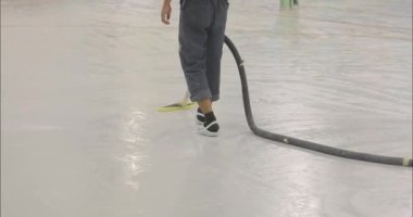 İnşaatçı inşaat alanını elektrikli süpürge kullanarak tozdan temizliyor. İnşaat alanını tozdan temizlemek. İşi bitirdikten sonra polimer zemini vakumlama işlemi.