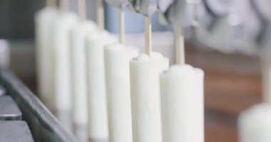 The chocolate drips nicely off the ice cream. Chocolate dripping from ice cream slow motion. Ice cream is dipped in chocolate at the factory.