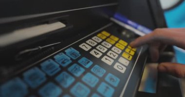 Makine operatörü CNC makinesinin tuşlarına basıyor. Yüksek hassasiyetli makine kontrolü.