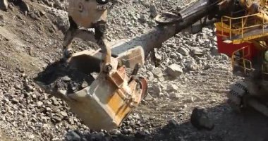 Büyük bir maden kazıcısı bir maden kamyonunu demir madenine yüklüyor.
