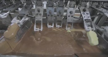 Ice cream is dipped in chocolate. Ice cream factory. Ice cream in chocolate glaze.