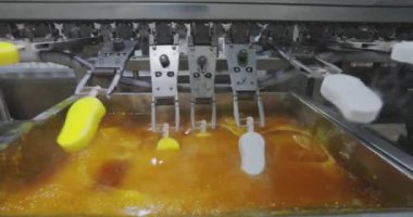 Ice cream is dipped into a container with fruit glaze. Colorful bright ice cream on the conveyor. Ice cream production.
