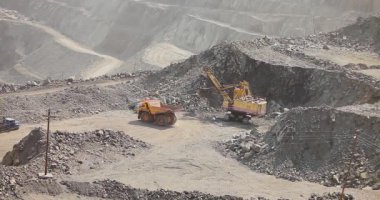 Büyük bir maden kazıcısı bir maden kamyonunu demir madenine yüklüyor.