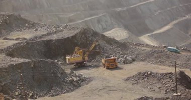 Büyük bir maden kazıcısı bir maden kamyonunu demir madenine yüklüyor.