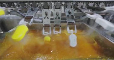 Ice cream is dipped into a container with fruit glaze. Colorful bright ice cream on the conveyor. Ice cream production.
