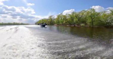 Bir motorlu tekne nehirde yüzüyor. Bir devriye botu nehir boyunca gidiyor. Askerî bir gemi nehirde yelken açar..