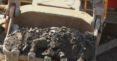 Büyük bir maden kazıcısı bir maden kamyonunu demir madenine yüklüyor.