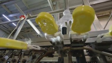 Ice cream is dipped into a container with fruit glaze. Colorful bright ice cream on the conveyor. Ice cream production.