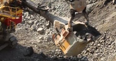 Büyük bir maden kazıcısı bir maden kamyonunu demir madenine yüklüyor.