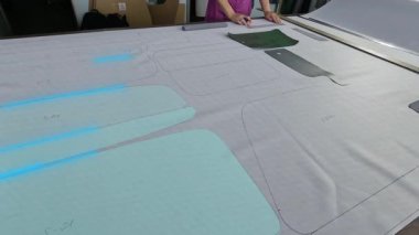 Kumaş kesimi. Fabrikada el yapımı kumaş kesimi. Fabrikada bir kadın kumaş kesiyor.