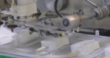 Apparatus for sorting ice cream. Ice cream dosing machine on a conveyor line. Automated conveyor line. Food production.