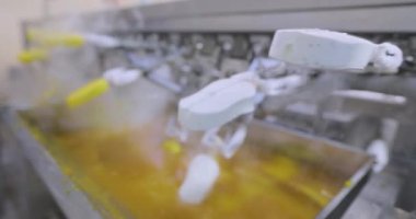 Ice cream is dipped into a container with fruit glaze. Colorful bright ice cream on the conveyor. Ice cream production.