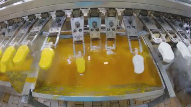 Ice cream is dipped into a container with fruit glaze. Colorful bright ice cream on the conveyor. Ice cream production.