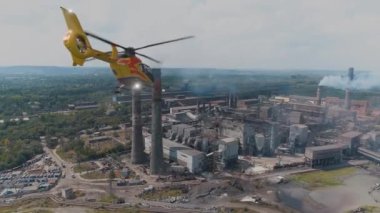 Helikopter büyük bir çelik veya kimya fabrikasının üzerinde uçuyor. Hava kirliliğinin denetlenmesi ve izlenmesi.