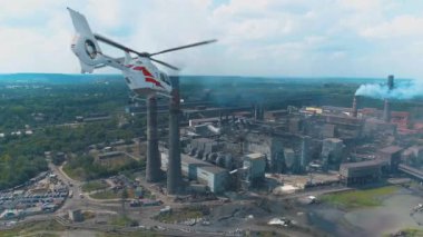 Helikopter büyük bir çelik veya kimya fabrikasının üzerinde uçuyor. Hava kirliliğinin denetlenmesi ve izlenmesi.