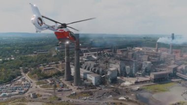 Helikopter büyük bir çelik veya kimya fabrikasının üzerinde uçuyor. Hava kirliliğinin denetlenmesi ve izlenmesi.