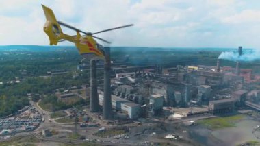 Helikopter büyük bir çelik veya kimya fabrikasının üzerinde uçuyor. Hava kirliliğinin denetlenmesi ve izlenmesi.