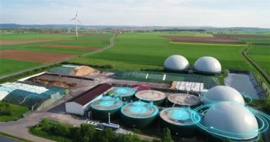 Yeşil tarlalardaki biyogaz fabrikası ve çiftliği. Biyokütlenin yenilenebilir enerjisi. Modern tarıma havadan bakış