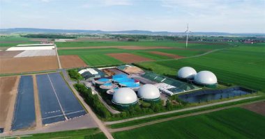 Yeşil tarlalardaki biyogaz fabrikası ve çiftliği. Biyokütlenin yenilenebilir enerjisi. Modern tarıma havadan bakış