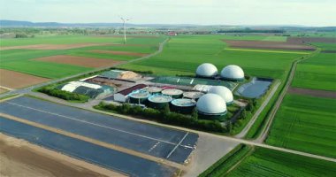 Yeşil tarlalardaki biyogaz fabrikası ve çiftliği. Biyokütlenin yenilenebilir enerjisi. Modern tarıma havadan bakış