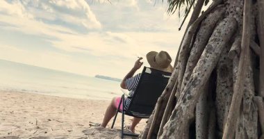 Adam tropikal ülkede plajda marihuana içiyor. Ot iç, esrar iç.