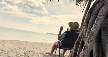 Adam tropikal ülkede plajda marihuana içiyor. Ot iç, esrar iç.