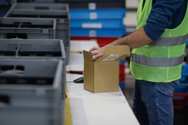 Bükreş, Romanya - 7 Kasım 2022: Sığ alan derinliği (seçici odaklı) bir e-ticaret ve dağıtım şirketinde çalışan bir adamın ayrıntıları.