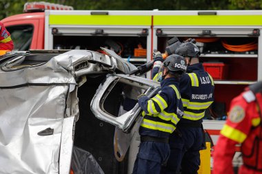 Otopeni, Romanya - 15 Mayıs 2023: Romen ilk müdahale ekipleri, itfaiyeciler ve sağlık görevlileri, tatbikat sırasında motosiklet kazası mağdurunu kurtarmak ve kurtarmak için eğitim aldılar.