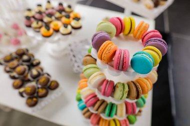 Şekerle dolu bir masada çok renkli badem kurabiyeleriyle sığ alan derinliği (seçici odak) ayrıntıları.