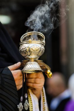 Ortodoks Hıristiyan rahibenin elinde tütsü tütsüsü tutarken sığ alan derinliği (seçici odak) ayrıntıları