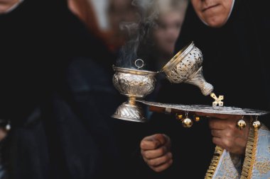 Ortodoks Hıristiyan rahibenin elinde tütsü tütsüsü tutarken sığ alan derinliği (seçici odak) ayrıntıları