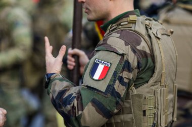 Bükreş, Romanya - 1 Aralık 2023: Romanya Ulusal Günü askeri geçidi sırasında üniformalı bir Fransız askerin ayrıntılarıyla sığ alan görüntüsü.