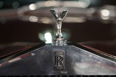 Bükreş, Romanya - 21 Nisan 2024: Eski Rolls Royce model lüks bir arabanın ön kısmı ve amblemi.