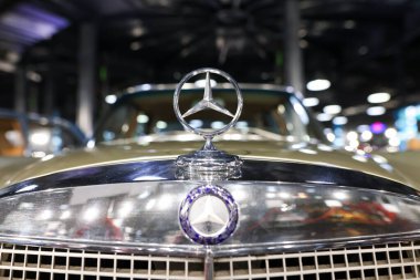 Bükreş, Romanya - 21 Nisan 2024: Eski bir Mercedes lüks otomobilin ön kısmı ve amblemi.